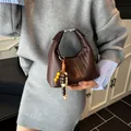 Dark brown woven hobo handbag with elegant beaded charm and metallic buckle closure - With Pendant / Coffee