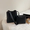 Conjunto minimalista de bolso cubo negro textura lichi y neceser a juego en cama - Estilo Bolso Cubo Y Neceser / Negro