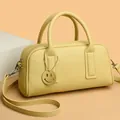 Classic yellow litchi leather Boston bag with smiley charm and crossbody strap for women - Yellow