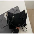 Black vintage hobo bag with contrast stitching and small coin purse on grey suit - Black