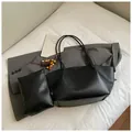Ensemble sac cabas noir minimaliste avec pochette sur un fond de lit blanc douillet - Noir Avec Pendentif