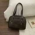 Détails macro d'un sac en similicuir marron brillant avec rivets en forme de cœur - Marron