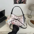 Bolso medialuna rosa y negro con bordado de lazo y detalle de colgante de corazón metálico - Rosa