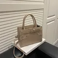 Elegant beige square handbag with top handles and adjustable strap in a vintage style - Khaki