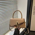 Elegant beige shoulder bag with asymmetric flap and golden V-shaped buckle hardware - Khaki