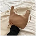 Détail du sac demi-lune beige minimaliste avec texture grainée et bandoulière fine - Kaki