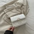 Weiße Stepptasche mit Perlenakzenten und Goldkette auf einem Blazer - Weiß