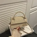 Elegante beige Umhängetasche aus Wildleder mit goldenem Logo und minimalistischem Griff - Khaki