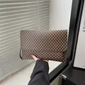 Pochette a busta marrone con monogramma in ecopelle e anelli per tracolla in metallo - Monogramma Caffè