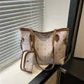 Elegant off-white tote bag with floral bear print and matching small pouch on a window sill - Brown