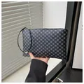 Close-up of long zip-around wallet with grey geometric pattern and wristlet strap - Clover - Black