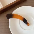 Eleganter Haarclip mit Bernstein-Farbverlauf und Hochglanz-Finish auf Keramikteller - Bernstein-Verlauf-Stil / Schwarzkaffee