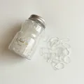 Jar of transparent high-elasticity rubber hair bands with silver screw cap on white background - Transparent White Jar Pack