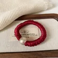 Elegante coletero de satén rojo con perla grande y goma de pelo de gran elasticidad - Coletero Perla Borgoña