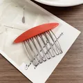 Minimalist bright orange resin hair comb with ten silver metal teeth on card - Pink