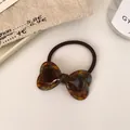 Elastic hair tie featuring a vintage tortoiseshell resin bow in warm amber brown - Blue Brown Tortoiseshell