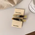 Set of two striped acetate hair clips in green and brown tones on display card - Black Apricot