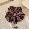 Deep brown velvet scrunchie for women with rich pleated texture and brand tag - Brown