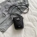 Mini black woven textured bucket bag with silver twist lock and crossbody strap - Black