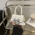 Chic white mini crossbody bag with silver metal bow and round handle for women - White