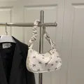 White corduroy hobo bag with black bow embroidery and ruffled shoulder strap - White