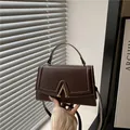 Bolso de mano marrón oscuro en cuero sintético con hebilla dorada en V y asa superior - Marrón