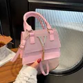 Elegant pink handbag with glitter finish and decorative gold V-shaped metal logo - Pink