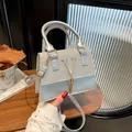Silver-gray structural crossbody bag with glitter flap, V-logo, and gold tassel charm - Silver
