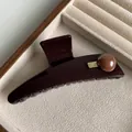 Large dark brown hair claw clip with golden metal plate and bead on velvet tray - Brown Round Bead