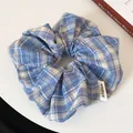 Blue and white plaid scrunchie hair tie with woven label on a white background - Light Blue Plaid Scrunchie