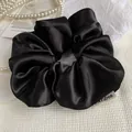 Elegant large black satin scrunchie with silky luster and minimalist brand label - Black