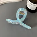 Large light blue holographic hair claw clip with iridescent finish and metal spring - Cross Twist Hair Claw / Iridescent Sky Blue