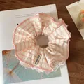 Pink and white striped scrunchie with lace trim and brand label on a wooden table - Pink Plaid Large Scrunchie