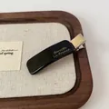 Pince à cheveux élégante en acétate noir avec texte Barrette La France doré pour femme - Pince à bec de canard noire