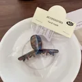 Handmade acetate claw clip in dark brown and blue tortoiseshell finish on a plate - Blue Brown Cross Claw