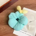 Sweet light blue floral scrunchie for girls with a yellow bow accent on wooden background - Blue Bowknot Scrunchie