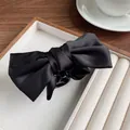 Classic black satin bow claw clip for women featuring elegant silky fabric and hair grip - Black