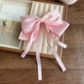 Elegant light pink satin hair bow clip with long streamers on a wooden tray - Pink