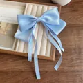 Light blue satin bow hair clip with long ribbons on a velvet jewelry tray - Blue