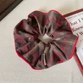 Vintage red plaid scrunchie with fabric texture and red trim on a textured background - Red Plaid