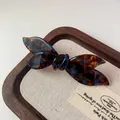 Elegant bow hair clip with blue and brown tortoiseshell pattern and gold accents - Blue Brown