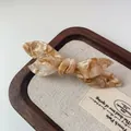 Elegant acetate bow hair clip with brown amber pattern on a canvas display tray - Milk Coffee