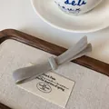 Eleganter grauer Marmor-Haarclip aus Acetat mit Schleife auf einem Holztablett - Grauer Federclip