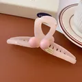 Pinza per capelli in resina rosa con perle e logo dorato su superficie di pelle - Rosa Incrociato
