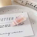 Elegant semi-transparent pink marble effect triangle hair clip on a white card - Triangle