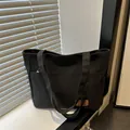 Bolso tote minimalista de lona negra con bolsillos laterales para uso diario - Negro