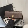 Bolso de mano marrón oscuro con textura trenzada, cierre dorado y correa ajustable - Marrón