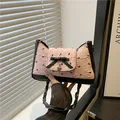 Elegante borsa sottobraccio rosa con motivo a fiocco, finiture nere e ciondolo a cuore - Rosa
