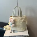 Cremefarbene Beuteltasche aus Oxford-Stoff mit breitem Gurt und Plüschhasen-Anhänger - Beige Mit Anhänger