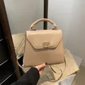 Elegant apricot trapezoid handbag with metallic rotating clasp and crossbody strap - Khaki